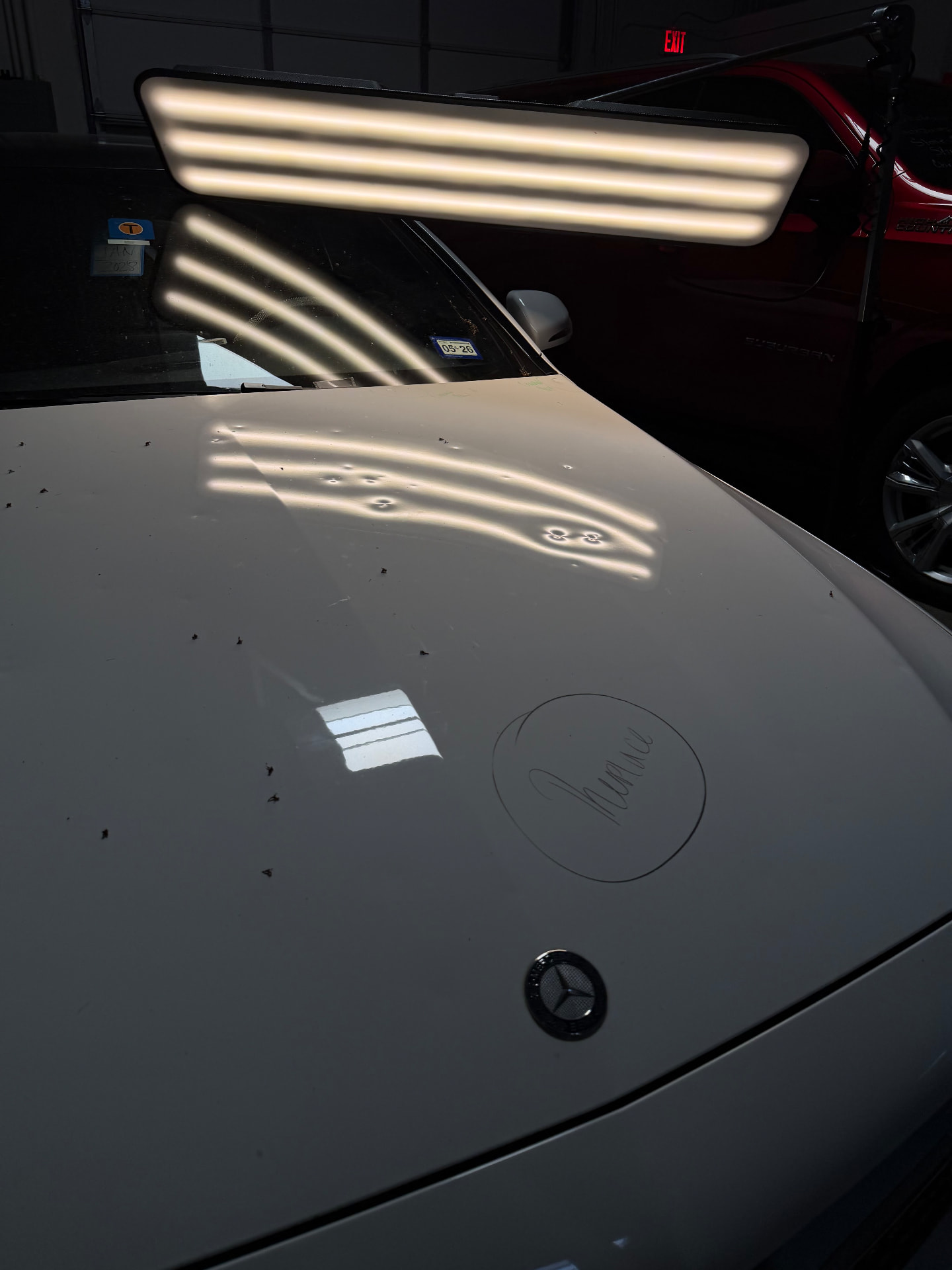 Mercedes-Benz hood — dents circled and mapped under reflective lighting.